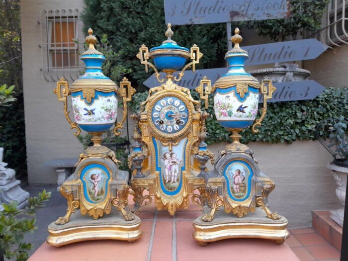 A 19th Century French  Gilt Metal And Porcelain Clock Garniture Set On Original Giltwood Bases And Original Key