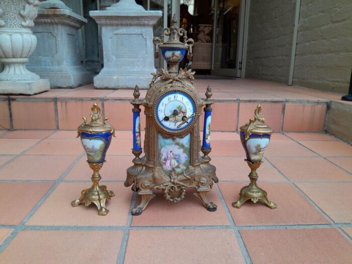 A 19th Century French Garniture Set With Gilt Bonze Clock With Key  And Pair Of Gilt Metal Porcelain Garniture On Velvet Bases