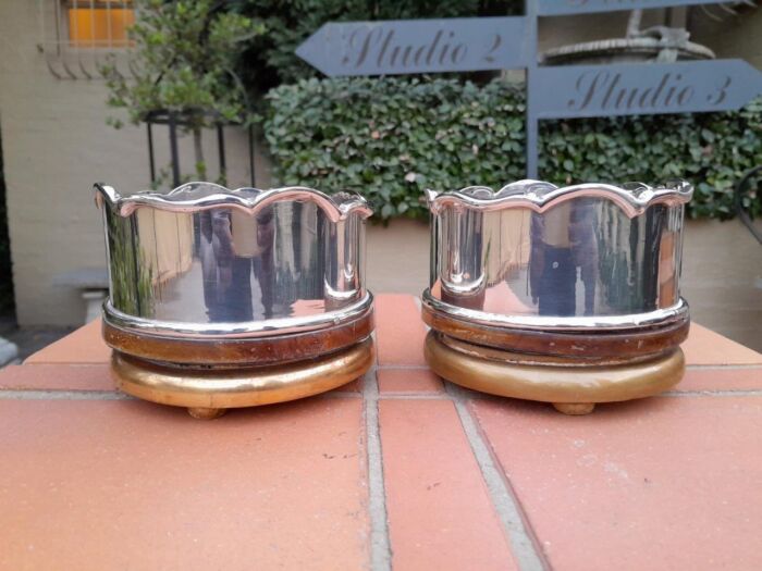 A Pair Of Silver-Plate Wine Bottle Coasters On Wooden Bases