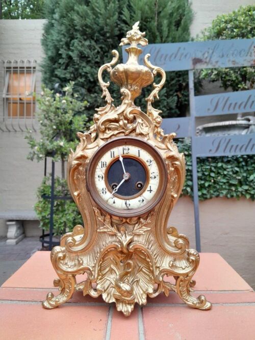 An Antique French Rococo Style Ormolu Clock with Key