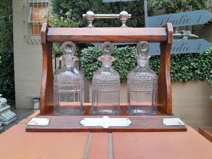 An English Oak Tantalus with 3 Glass Decanters & Metal Hardware