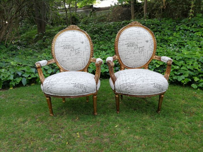 A Pair of French Style Carved and Gilded Armchairs Upholstered in a Custom-made Script on Linen Fabric for The Crown Collection