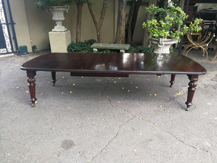 A three meter Victorian mahogany extending dining table on carved legs and castors