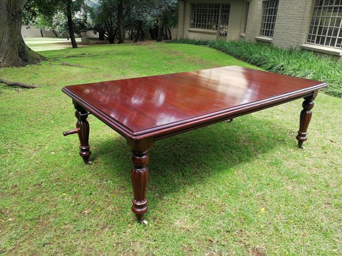 A Victorian Style Mahogany extending ten-seater dining room table on brass castors and with winding crank (10 Seater) - Image 4