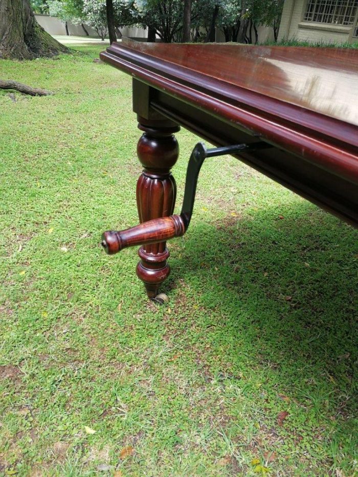 A Victorian Style Mahogany extending ten-seater dining room table on brass castors and with winding crank (10 Seater) - Image 6