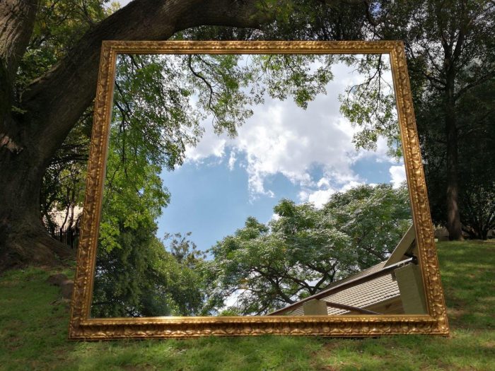 A large gilded mirror with ornate frame