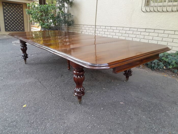 A Massive and Rare Victorian Mahogany Dining / Boardroom Extension table with Four Extensions and Fifth Supporting Leg in the Middle on Original Brass Castors - Image 5