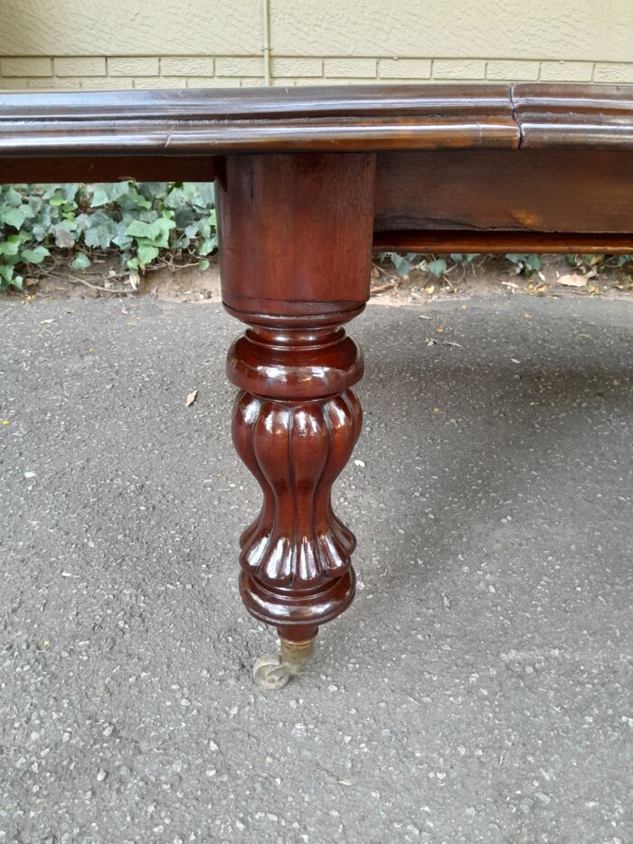 A Massive and Rare Victorian Mahogany Dining / Boardroom Extension table with Four Extensions and Fifth Supporting Leg in the Middle on Original Brass Castors - Image 7