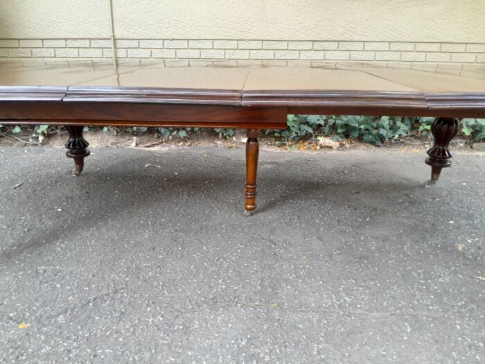 A Massive and Rare Victorian Mahogany Dining / Boardroom Extension table with Four Extensions and Fifth Supporting Leg in the Middle on Original Brass Castors - Image 8