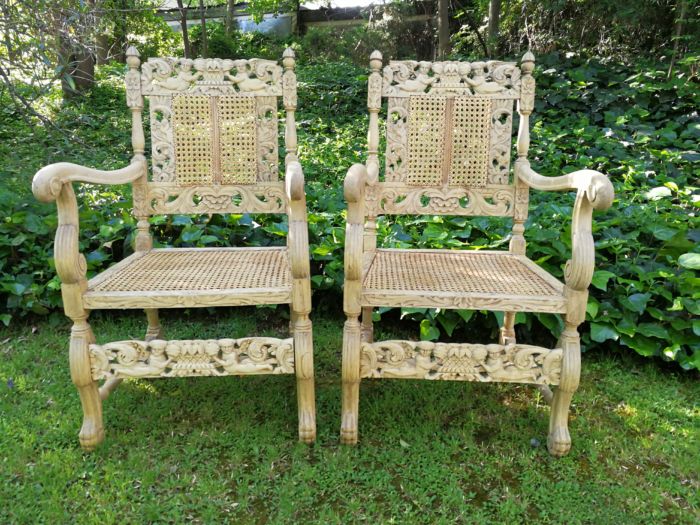 A Pair Or Ornately Carved And Bleached / Natural Wood Finish With Redone Rattan Arm Chairs