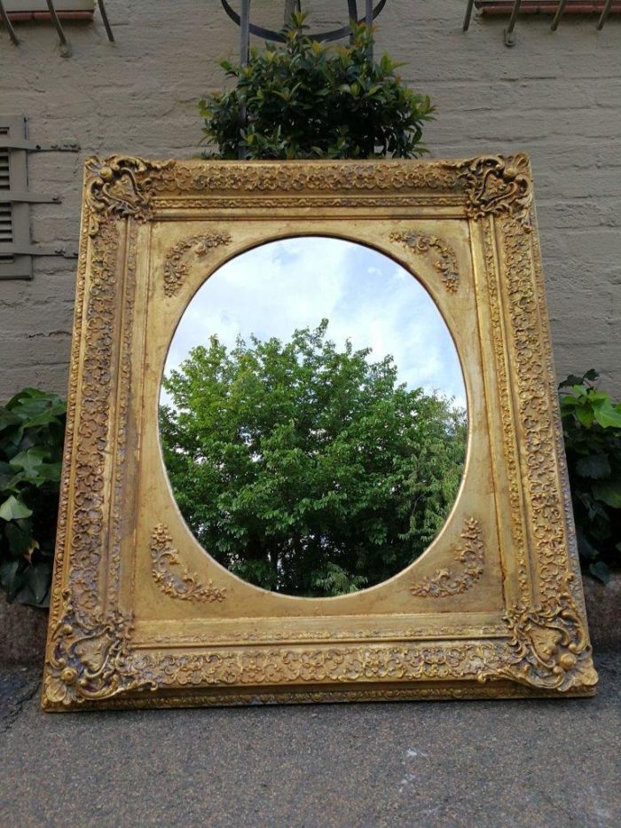 An Early 20th Century Gilded Oval Mirror Within A Rectangular Frame