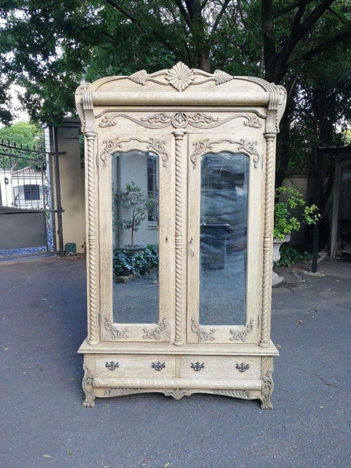 An Antique Victorian English Carved And Bleached Oak Armoire With Bevelled Mirror Doors And Two Drawers