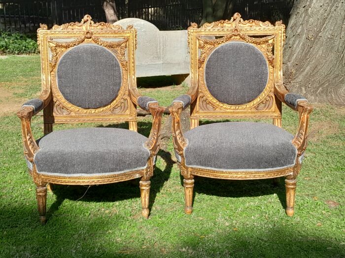 A 20th Century French Style Ornately Carved and Gilded Pair of Arm Chairs