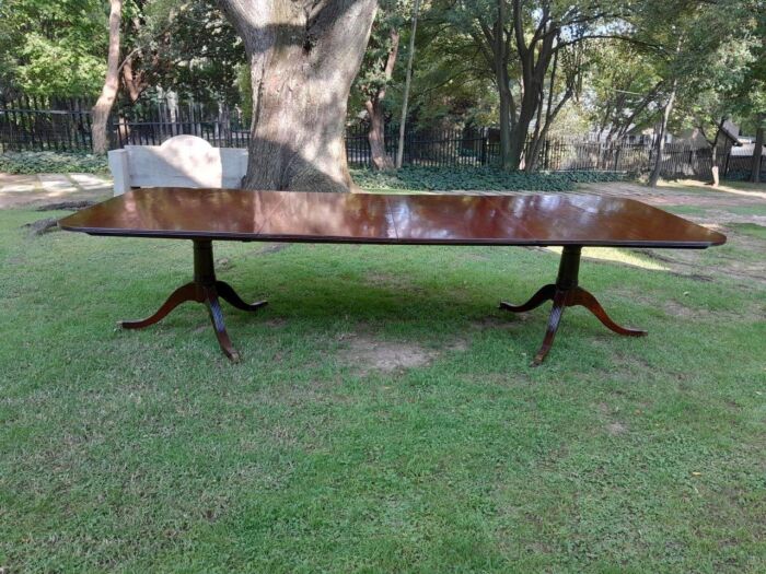 A 20th Century Regency-style Mahogany Extending Dining Table On Casters with Two Leaves and One Other