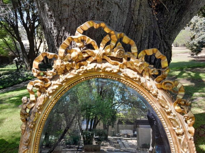 A French Rococo Style Ornately Carved and Gilded Oval Bevelled Mirror - Image 4