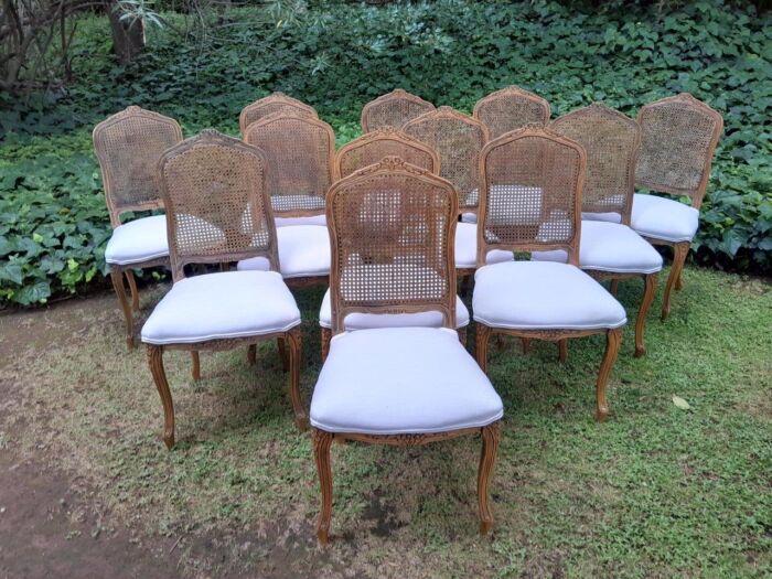 A Rare 20th Century Set Of Twelve French Colonial Style Walnut Rattan Dining Chairs