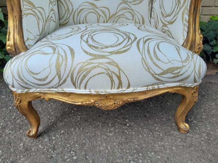 A French Style Pair of Hand Gilded Carved Wingback Chairs Upholstered in a Custom Made for The Crown Collection Cotton / Linen Fabric - Image 6