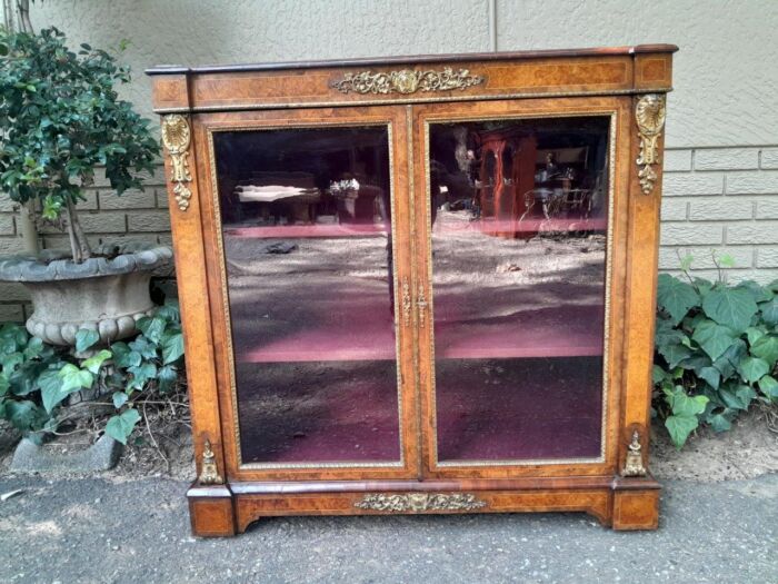 A Victorian Walnut Credenza / Display Cabinet With Gilt Mounts And Glazed Doors With Shelves On Bracket Feet