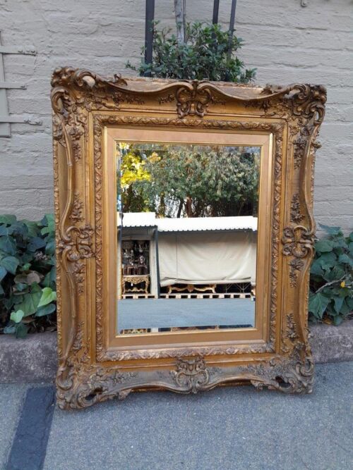 An Ornately Carved Gilt Framed Bevelled Mirror