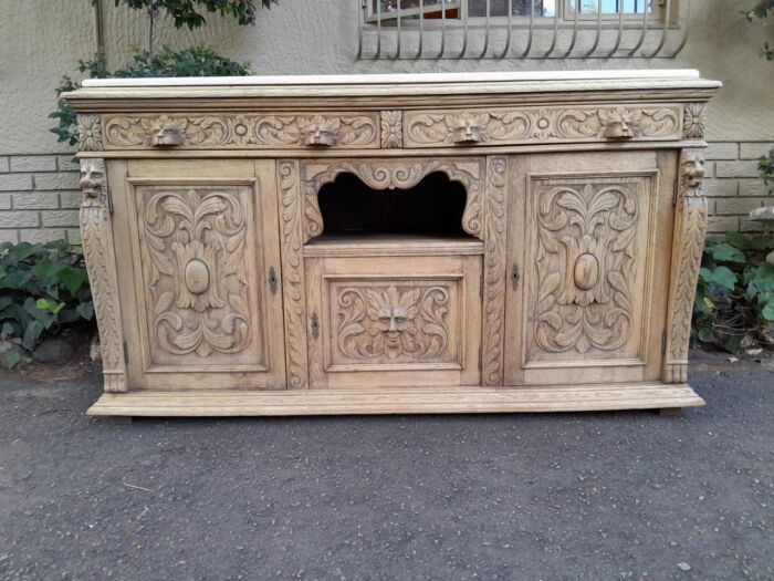 An Early 20th Century Heavily Carved Oak Sideboard / Buffet / Drinks Table With Two Drawers And Two Doors And Removable Middle Shelf In A Contemporary Bleached Finish