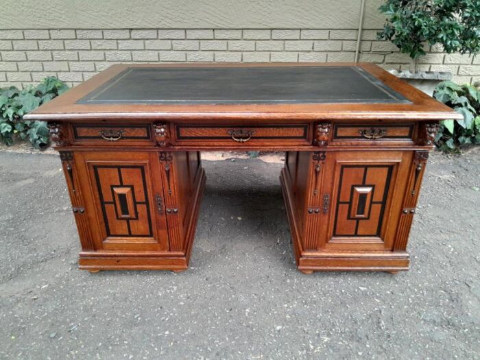 An Edwardian Circa 1910 Oak And Ebonised Desk With Gilt Tooled Green Leather Top Above Three Drawers Inside The Doors