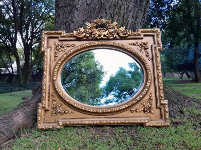 A French Rococo Style Ornately Carved and Gilded Bevelled Mirror