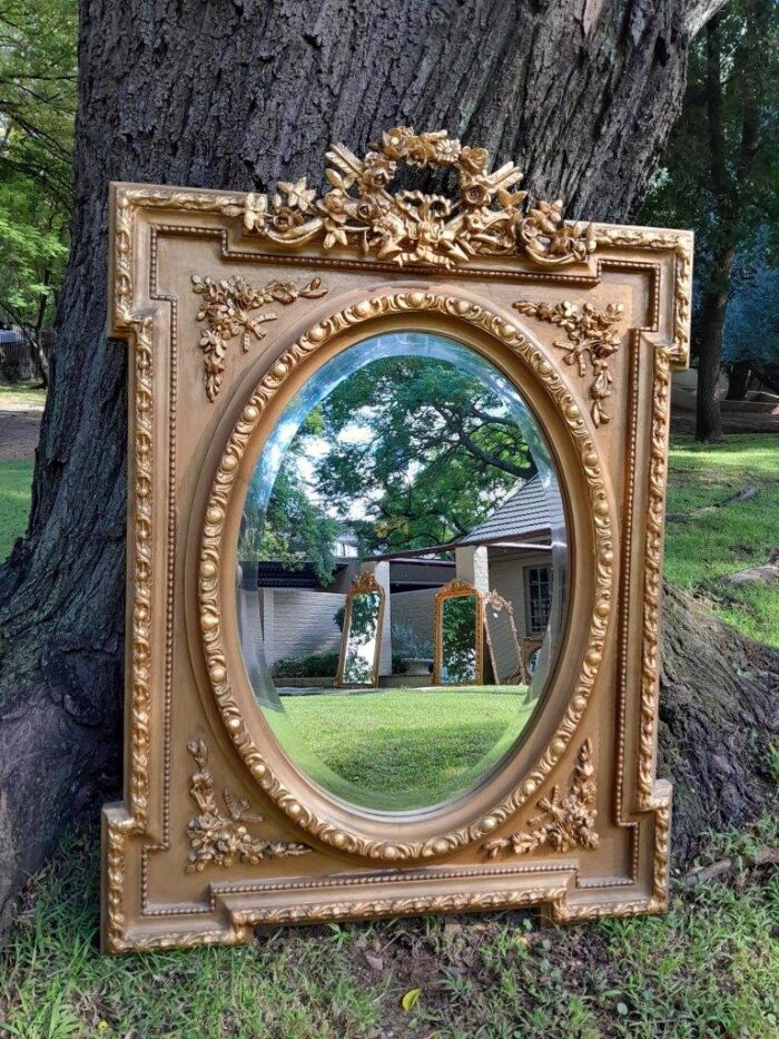 A French Rococo Style Ornately Carved and Gilded Bevelled Mirror