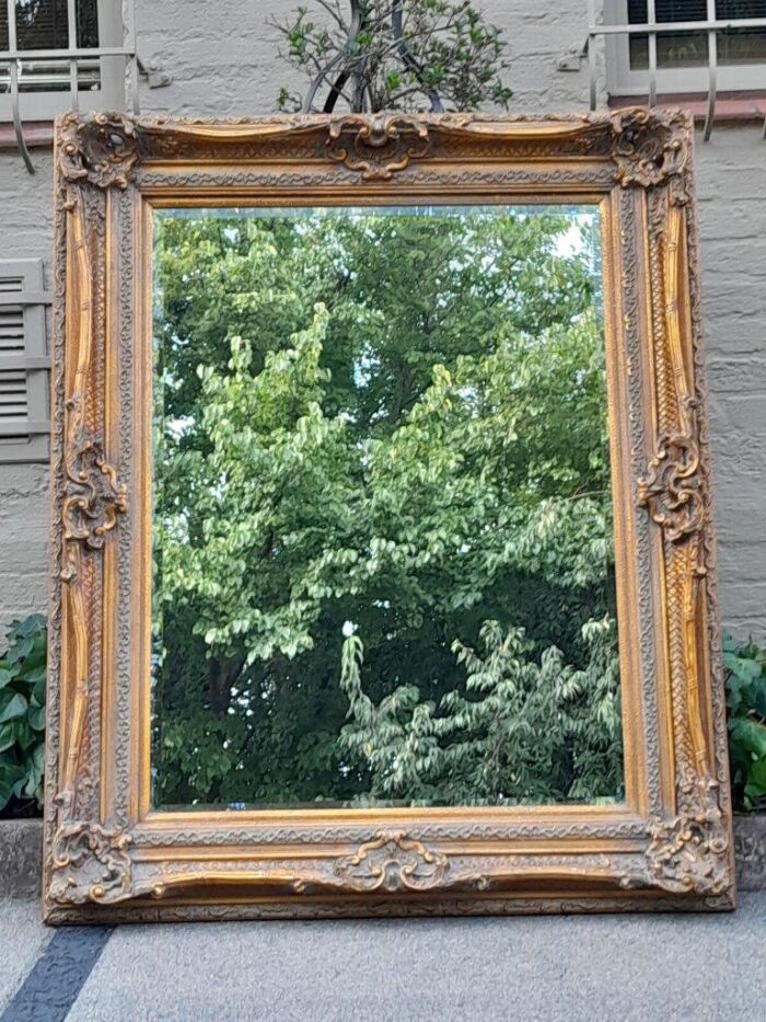 A 20th Century Heavily Carved  and Gilded Bevelled Mirror