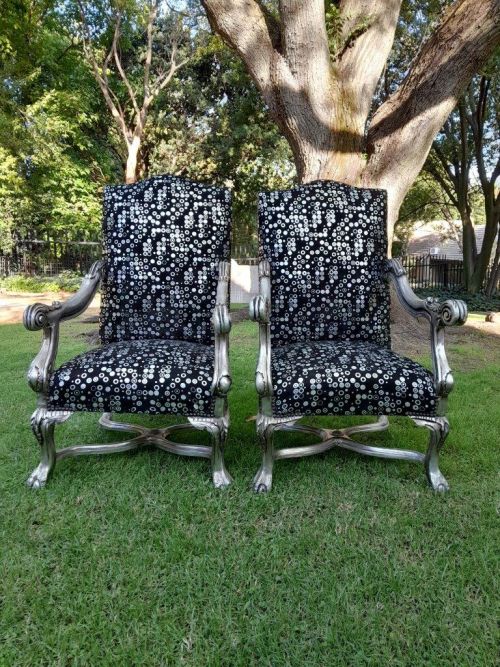 A 20th Century French Style Ornately Carved Pair Of Arm Chairs Hand Gilded And Upholstered In A Deep Buttoned Leather