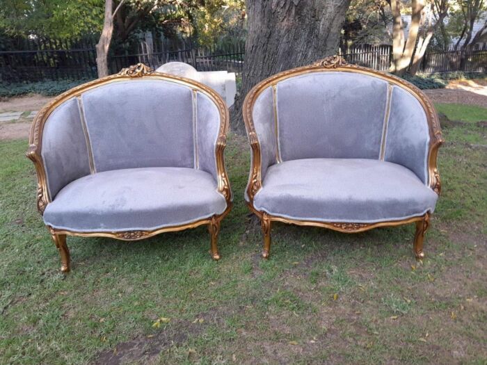 A Pair of French Ornately Carved and Gilded Bergere Chairs