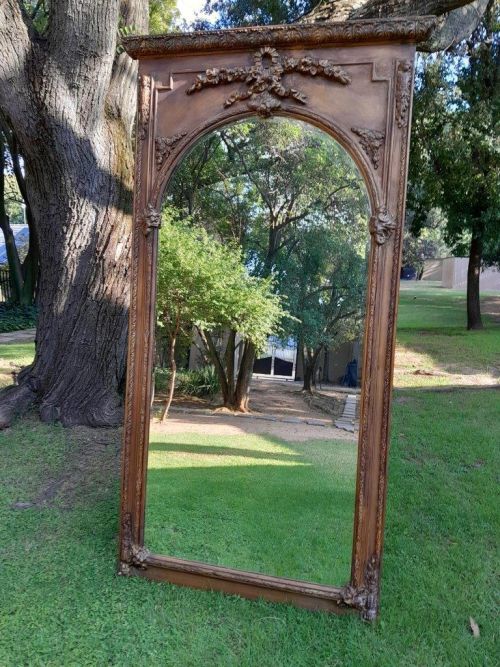 A French Style Ornately Carved And Gilded Bevelled Mirror Of Large Proportions