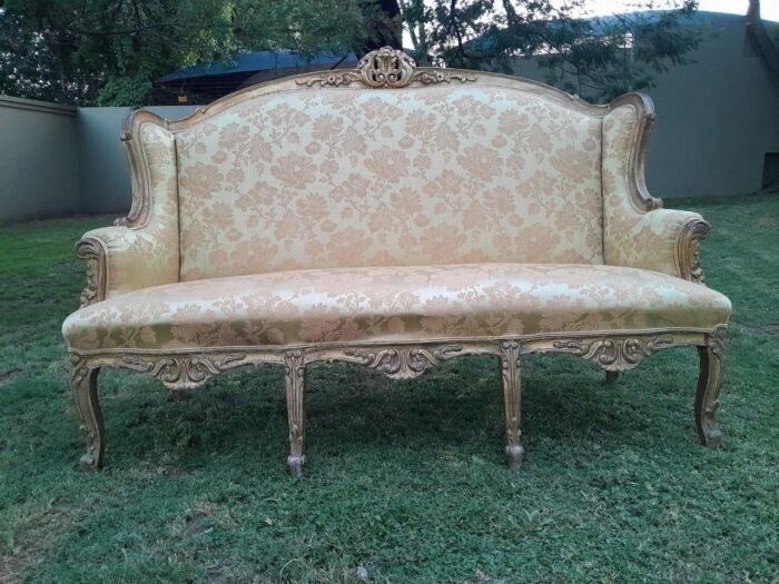 An Early 20th Century French Style Ornately Carved and Gilded Wingback Settee 