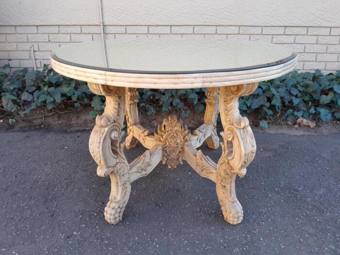 A 20th Century Ornately Carved Circular Wooden Table In A Contemporary Bleached Finish And With A Bevelled Mirror Top