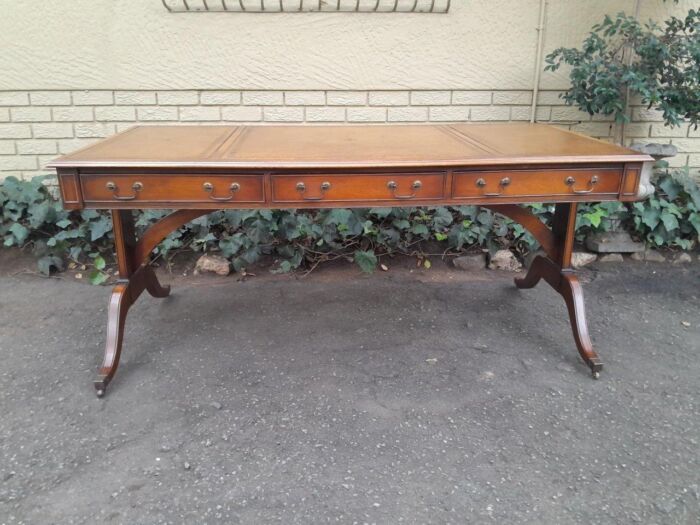 A 20th Century Victorian Style Mahogany Library Desk With  Original Gilt Tooled Leather Inserts On Castors