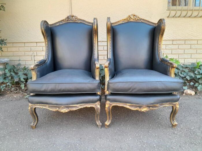 A Circa 1900s French Style Pair Of Carved Giltwood Wingback Chairs Upholstered In Leather