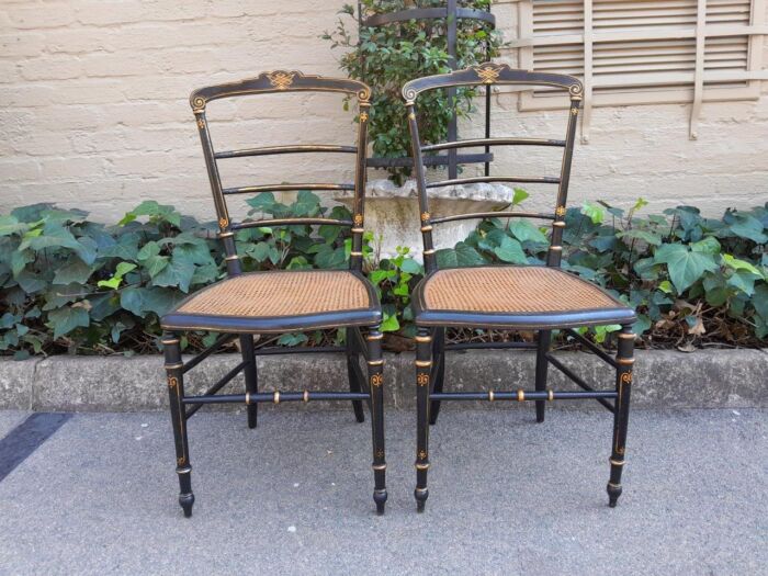 A Late 19th Century Circa 1880s Pair Of Victorian Ebonised And Gilt Painted Wooden Rattan Chairs