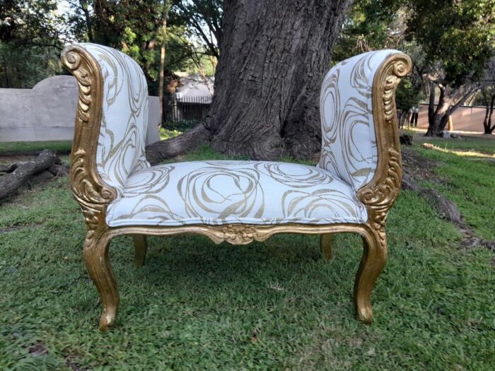 A French Style Ornately Carved Gold Painted Window Bench / Ottoman Upholstered In Hand Printed Gold Design Fabric 