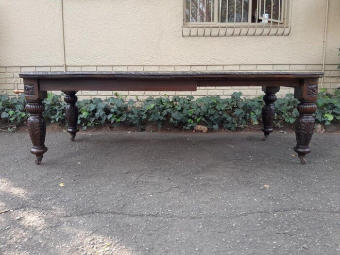 An Antique Victorian English Carved Oak Extending Dining Table on Castors and with Crank Handle