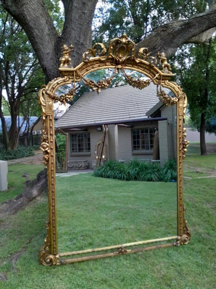 A French Style Ornately Carved And Gilded Bevelled Mirror Of Large Proportions