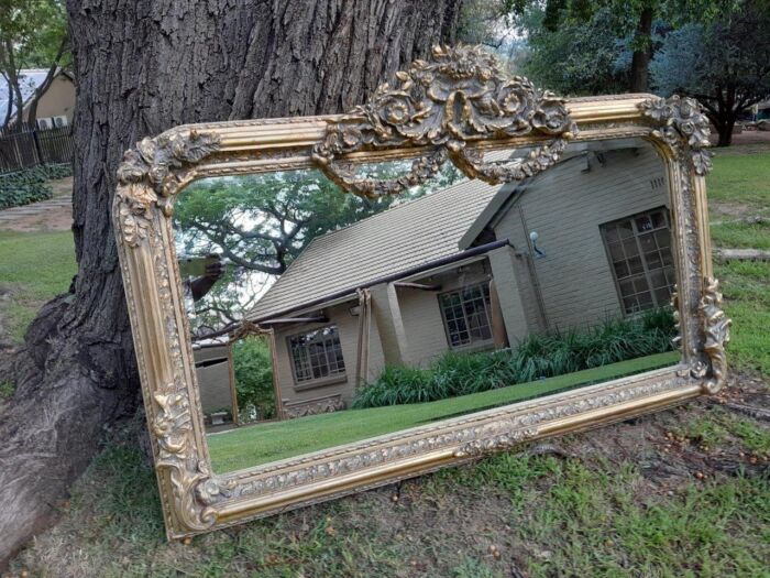 A French Rococo Style Ornately Carved And Gilded Bevelled Mirror