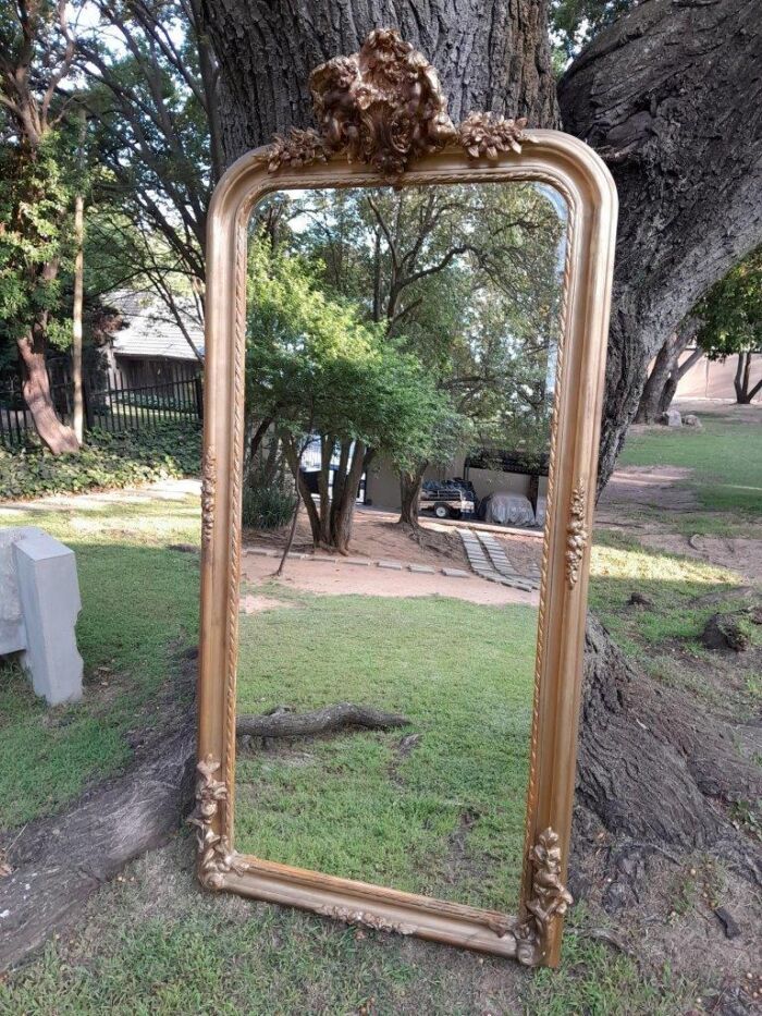 A French Rococo Style Ornately Carved And Gilded Bevelled Mirror