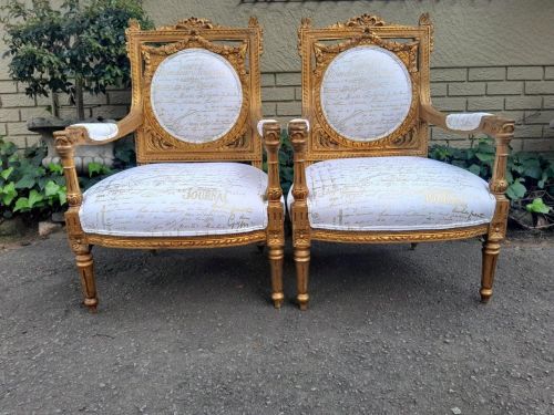 A 20th Century Pair Of French Ornately Carved And Gilded Armchairs