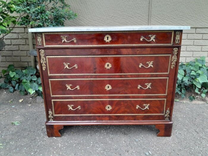 An Antique 19th Century French Louis Xvi Style Flame Mahogany Chest Of Drawer With Original Marble Top And Ormolu Mounts