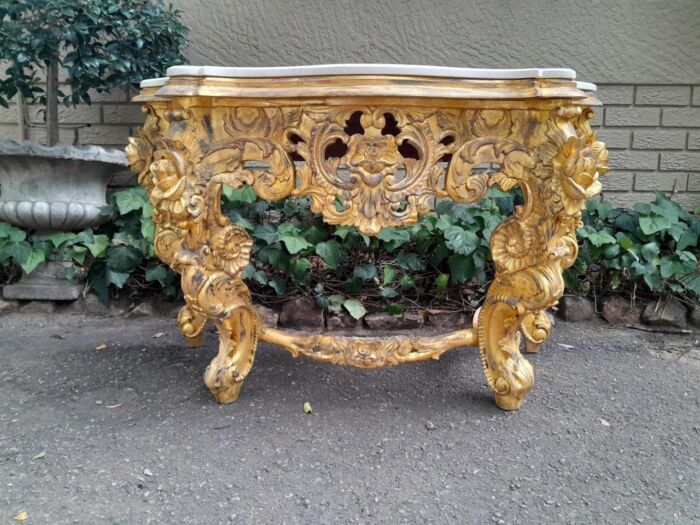 A 20th Century Heavily Carved and Hand Gilded with Gold Leaf Console Table with Cream Marble Top