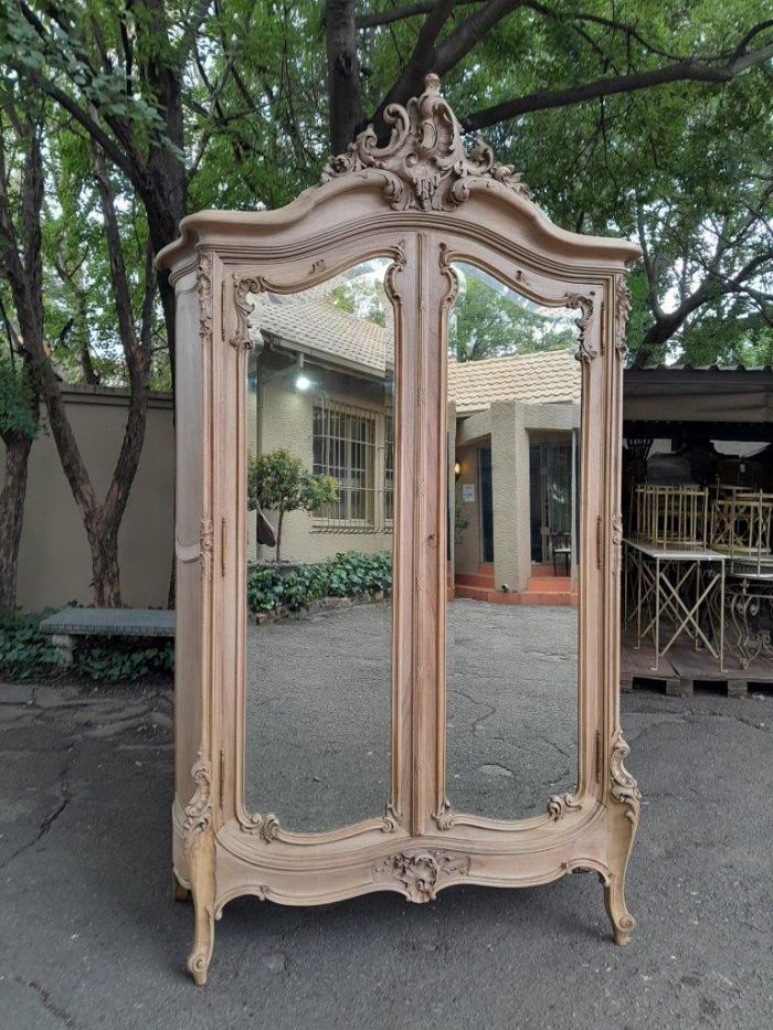 An Antique French Heavily Carved Oakd Two Door Armoire with Bevelled Mirrors and Four Shelves