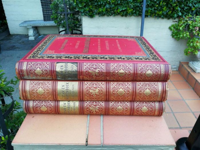 A Set Of Late 19th Century Circa 1885/1890 Extra-Large Size Decorative Books Entitled Stam En Wapenboek Van Aanzienlijke Nederlandsche Familien In Red Hardcovers With Gilt-Lettering And Tooling