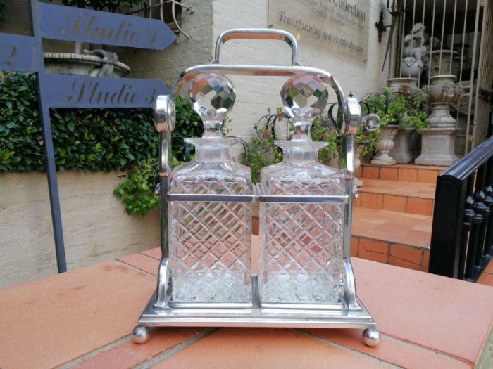 A Silver- Plate Tantalus With Two Cut-Glass Decanters