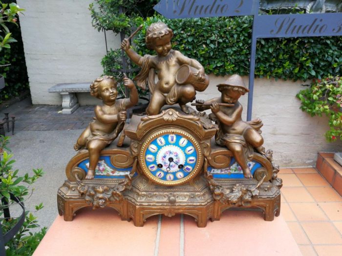 A 20th Century French Spelter And Gilt And Spelter Clock With Porcelain Plaques.  Has Key And Pendulum