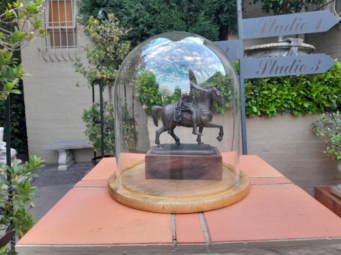 A Bronze Male Figurine On Horseback On Wooden Base In A Glass Cloche